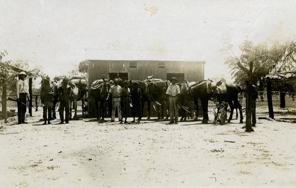 Lock-up at Police Station, Leichhardt's Bar, NT. Mounted Constable John Robert Johns is on the left. The third person from the left is Neighbour. He is a prisoner in chains which are held by the man second from the left.