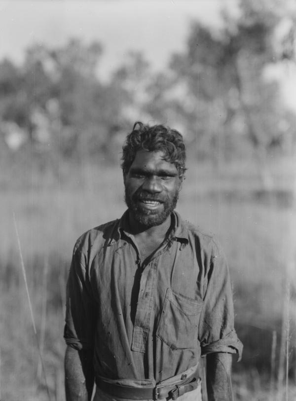 A smiling portrait of Ayaiga in an Australian bush setting. 