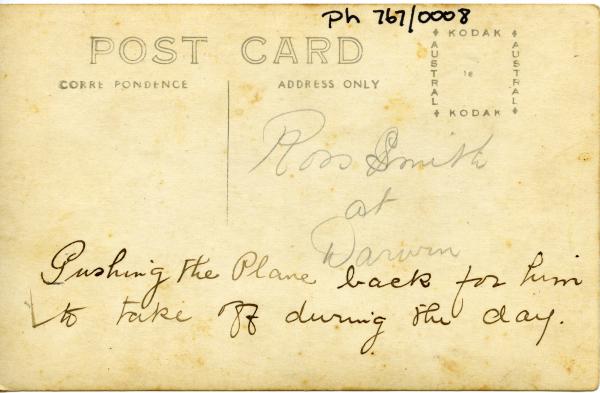 Text on reverse: Ross Smith at Darwin. Pushing the plane back for him to take off during the day 